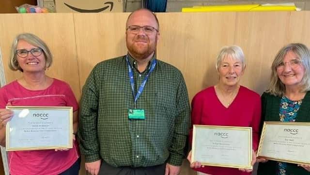 Melton Child Contact Centre volunteers, Helen Dickinson, Gill Devereaux and Sue Wait, receive their long service certificates from Phil Coleman, from the national body