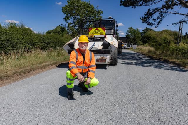 Councillor Charles Whitford, cabinet member for highways, transport and waste, on one of the roads being treated with 'surface dressing'