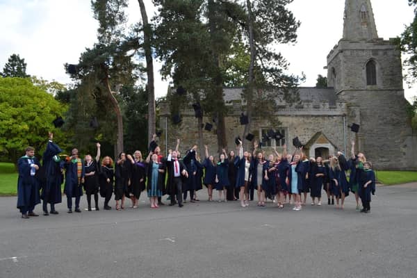 Students toss their caps in the air after SMB College Group's graduation day at Brooksby