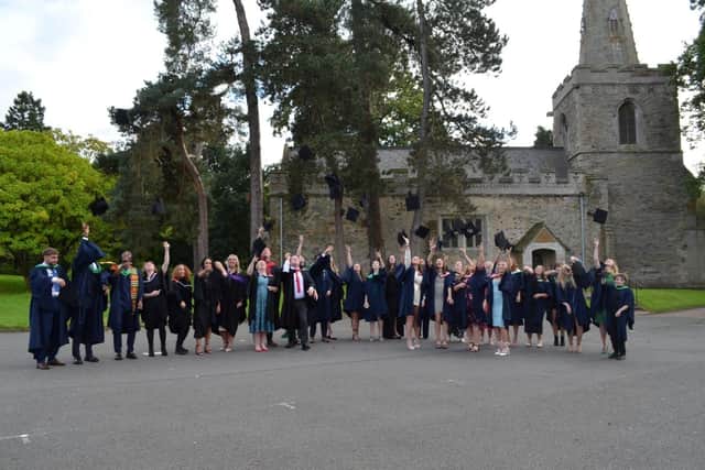 Students toss their caps in the air after SMB College Group's graduation day at Brooksby