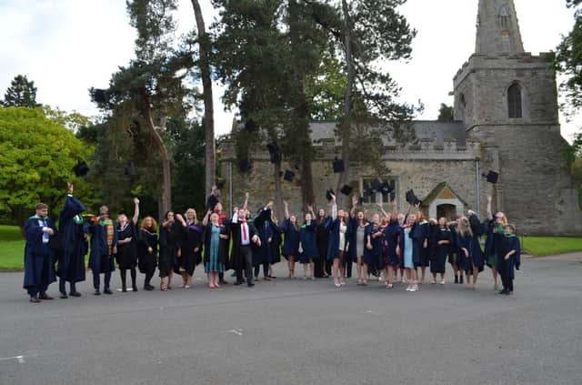 Students toss their caps in the air after SMB College Group's graduation day at Brooksby