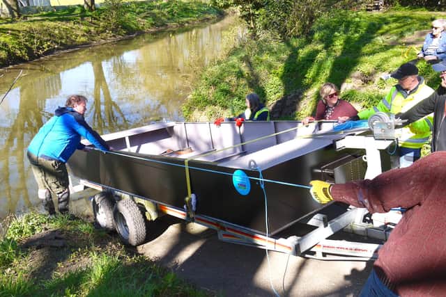 Melton and Oakham Waterways Society volunteers launch their new workboat