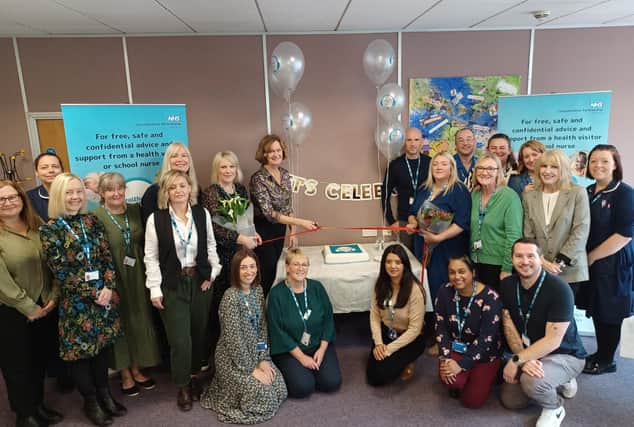 Colleagues gather to celebrate the launch of the Healthy Together Helpline, with director of families, young people, children, learning disability and autism services at Leicestershire Partnership NHS Trust, Helen Thompson (centre), cutting a ribbon to mark the occasion