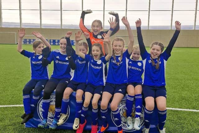Members of the Whitwick St John Baptist School girls' football team celebrating their new kits