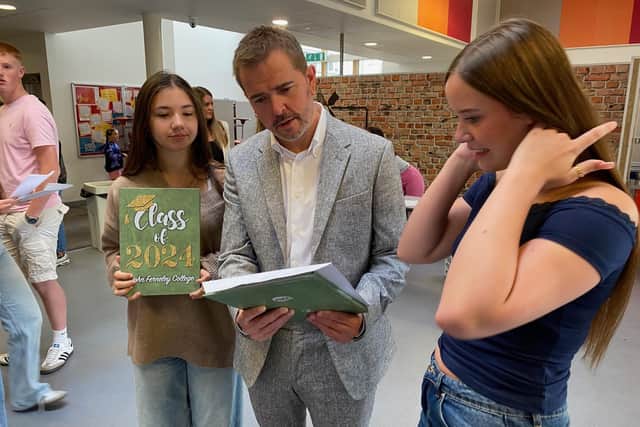 John Ferneley College head Terry Claridge check GCSE results with two students