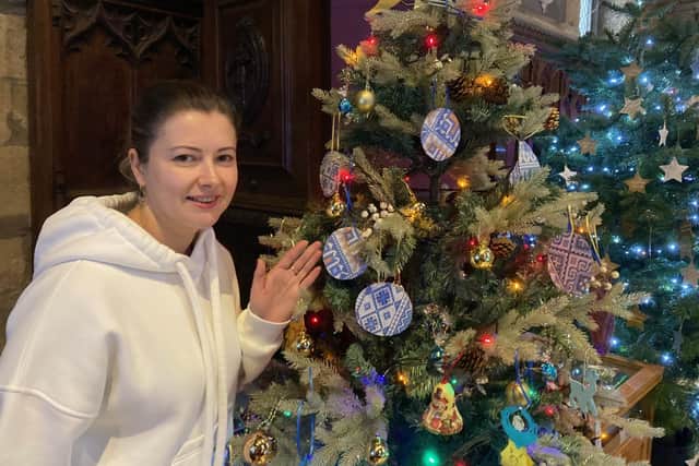 Melton Christmas tree festival opens to the public - Natalia Bahrova by the tree provided by Ukrainian guests of Melton