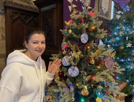 Melton Christmas tree festival opens to the public - Natalia Bahrova by the tree provided by Ukrainian guests of Melton