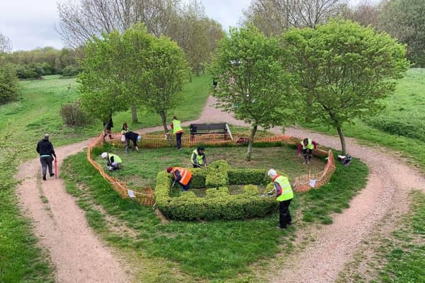 Friends of Melton Country Park volunteers adding their willow dragonfly sculptures to the bird hide