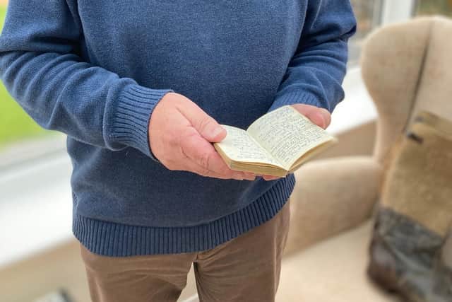 Malcolm Britton reads his father's wartime diary at his home in Frisby