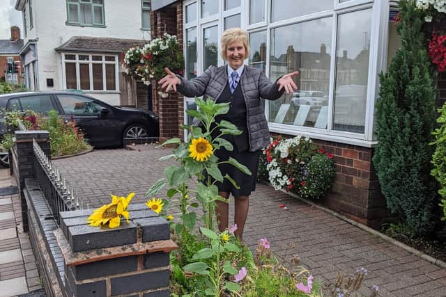 Jenny Barnes proudly shows off the new sunflowers outside her Melton funeral directors business