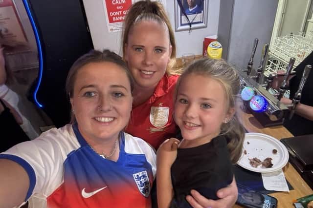 Gemma Fare, her daughter Annabelle who plays for an under 9s football team, and friend Sarah, celebrate England's win at The Cherry Tree pub in Melton