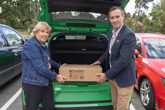 County councillor Adam Tilbury allocating Floodsax materials as part of the flood-prevention scheme to Blaby parish councillor Sue Jordan
