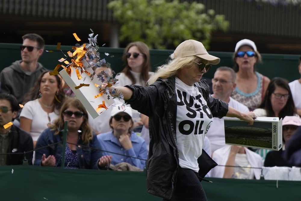 A Just Stop Oil protester runs onto Court 18 and releases confetti