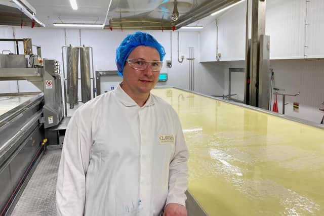 Team leader Rafal Opala checks a vat where milk is being prepared for the Stilton cheese making process