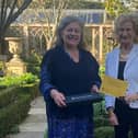 Lucy Hurst, National Garden Scheme county organiser,  presents a commemorative trowel and certificate to Dr Sarah Furness for opening their garden for 20 years
