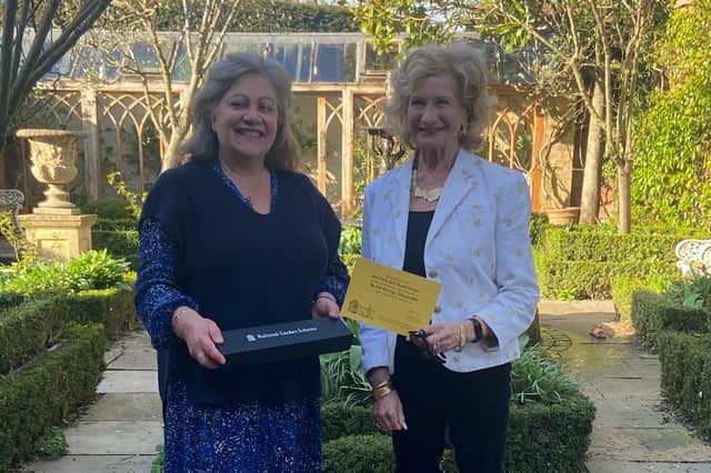 Lucy Hurst, National Garden Scheme county organiser, presents a commemorative trowel and certificate to Dr Sarah Furness for opening their garden for 20 years