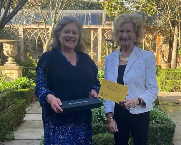 Lucy Hurst, National Garden Scheme county organiser,  presents a commemorative trowel and certificate to Dr Sarah Furness for opening their garden for 20 years