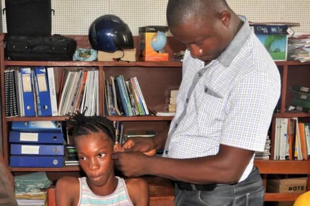 Staff in the Audiology Department support a child at St Joseph’s School for the Deaf, in Makeni, Sierra Leone