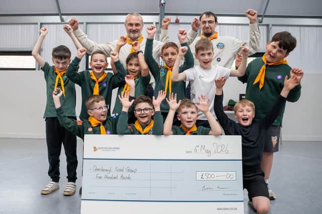 Scouts and leaders at the Queniborough group celebrate their cash donation from David Wilson Homes