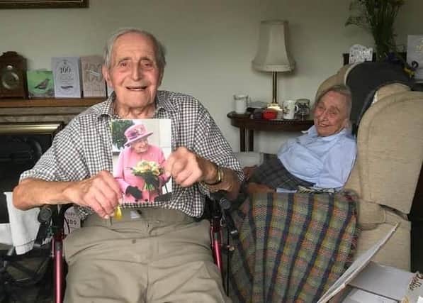 Dennis Kirk shows off his card from The Queen back in 2020 to mark his 100th birthday, with wife, Joan