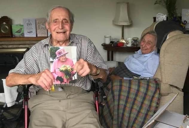 Dennis Kirk shows off his card from The Queen back in 2020 to mark his 100th birthday, with wife, Joan