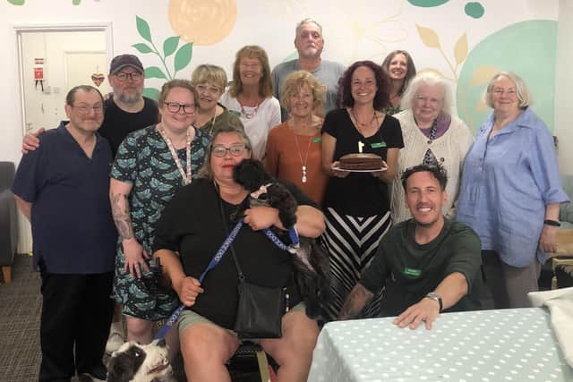 Volunteers and some of the attendees with centre manager Jenny Hendry with a cake celebrating the first birthday of the Pepper's - A Safe Place HQ in Nottingham Street
