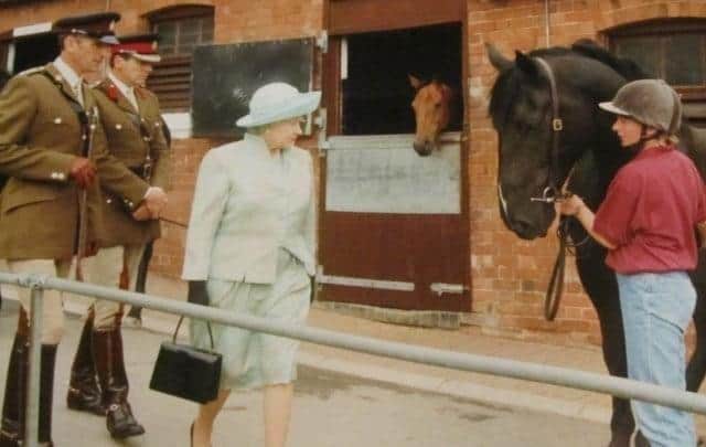 Maria Munro (holding the horse) meets The Queen during her visit to Melton's Defence Animal Centre in 1996