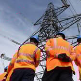 National Grid Overhead Line Apprentices stand below a electricity pylon at the National Grid training centre in Eakring, central England on April 28, 2025. (Photo by Darren Staples / AFP) (Photo by DARREN STAPLES/AFP via Getty Images)