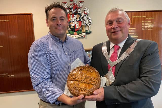 New Mayor of Melton, Councillor Tim Webster, is presented with a commemorative Melton Mowbray pork pie by Richard Griffiths, manager of the town's Dickinson and Morris Ye Olde Pork Pie Shoppe