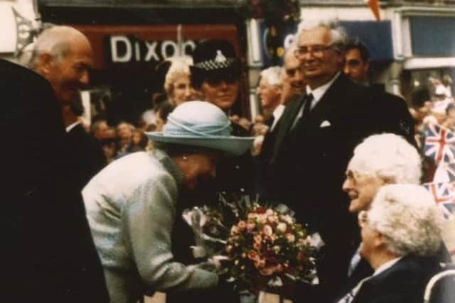 91-year-old Kath Wright presents flowers to The Queen during her visit to Melton in 1996