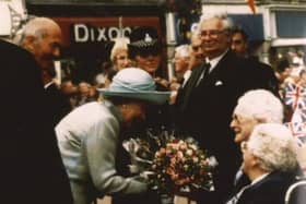 91-year-old Kath Wright presents flowers to The Queen during her visit to Melton in 1996