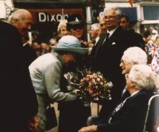 91-year-old Kath Wright presents flowers to The Queen during her visit to Melton in 1996