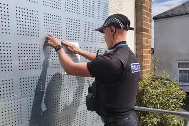 A police officer boards up the address in Rutland Street, Melton, after a court order was obtained