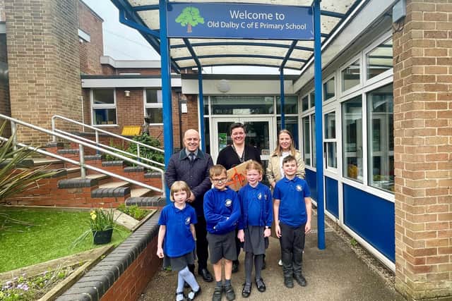 James Dawson and Hannah Jones, from Newton Fallowell, present a new laptop to Old Dalby Primary School headteacher Rosie Brown and some very excited pupils