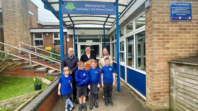 James Dawson and Hannah Jones, from Newton Fallowell, present a new laptop to Old Dalby Primary School headteacher Rosie Brown and some very excited pupils