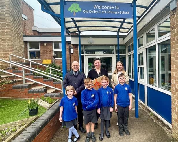 James Dawson and Hannah Jones, from Newton Fallowell, present a new laptop to Old Dalby Primary School headteacher Rosie Brown and some very excited pupils