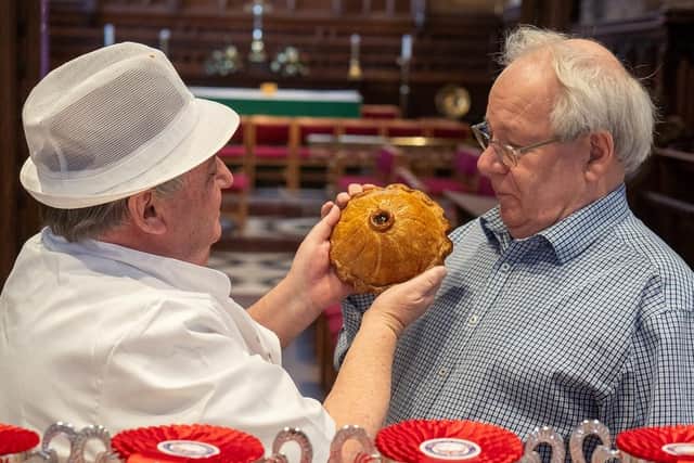 British Pie Awards organiser Matthew O'Callaghan (right) gets a close-up look at one of the 900 pies entered for this year's competition at St Mary's Church, in Melton Mowbray PHOTO Martin Elliott
