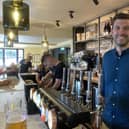 Tap & Run co-owner Harry Gurney toasts the reopening of the pub a year after it burned down