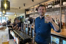 Tap & Run co-owner Harry Gurney toasts the reopening of the pub a year after it burned down