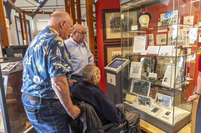 Bill Larder (seated), Greit Pijpers and historian Brian Fare look at the Arnhem exhibition at Melton Carnegie Museum