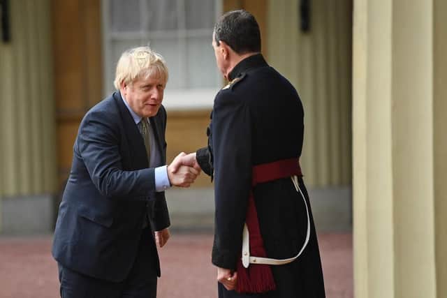Britain's Prime Minister and Conservative Party leader Boris Johnson (L) shakes hands with the Queen's Equerry-in-Waiting Lieutenant Colonel Charles Richards as he leaves Buckingham Palace in central London on December 13, 2019, after an audience with Britain's Queen Elizabeth II, where she invited him to become Prime Minister and form a new government. - Conservative Prime Minister Boris Johnson on Friday hailed a political "earthquake" in Britain after a thumping election victory which clears the way for the country to finally leave the EU next month after years of paralysing deadlock. (Photo by Victoria Jones / POOL / AFP) (Photo by VICTORIA JONES/POOL/AFP via Getty Images)