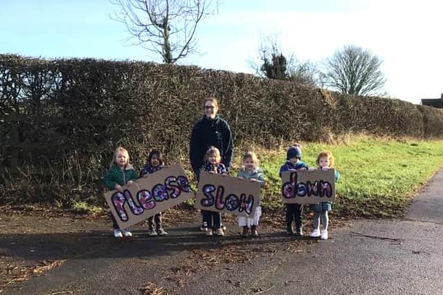 Children from the Roots to Wings nursery campaign on the roadside to stop drivers speeding through Wymondham