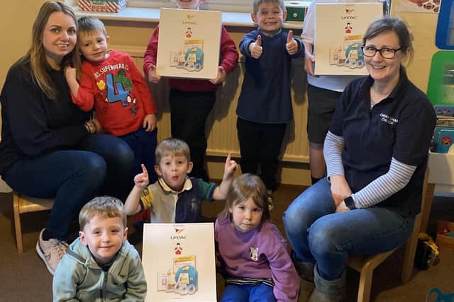 Debra Meakin (right) and Laura Gabriel with some of the children at Cheeky Cherubs Childcare and the LifeVac devices they raised money for