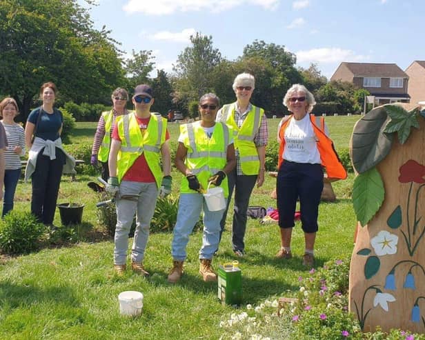 Members of the Friends of Melton Country Park tending the Covid Memorial beds and sculptures