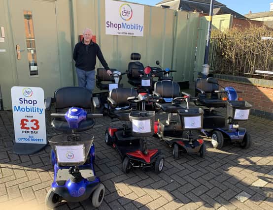 Shopmobility Melton Mowbray coordinator, Glyn Birch, with some of his stock of scooters and wheelchairs for hire in front of the newly-painted HQ
