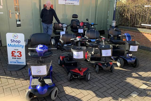 Shopmobility Melton Mowbray coordinator, Glyn Birch, with some of his stock of scooters and wheelchairs for hire in front of the newly-painted HQ