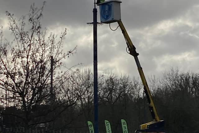A workman installs the first of the new HD CCTV cameras, on the bridge near the council offices, this morning