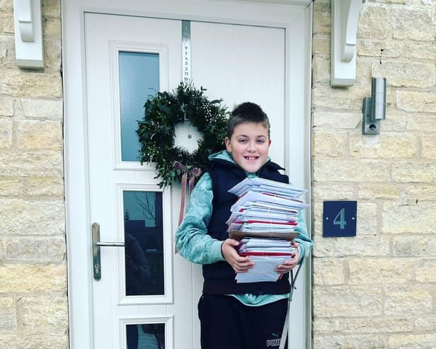 One of the 36th Melton Mowbray Scout Group with a pile of Christmas cards ready to be delivered