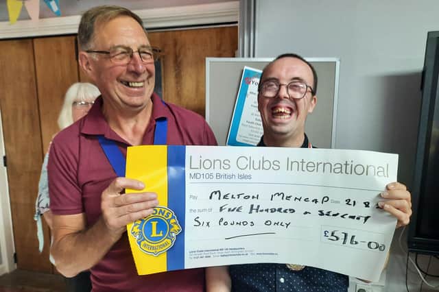 Edward Kitchen (right) proudly shows off a cheque for the amount raised at Melton Mencap's mini swimathon