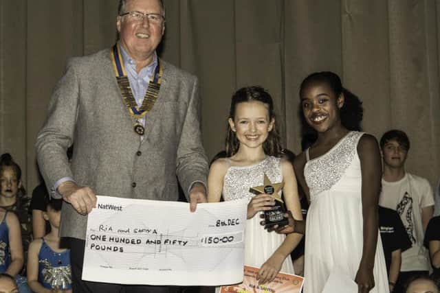 President of the Vale of Belvoir Rotary Club Adrian Cresswell presenting Ria and Safiya with £150 for finishing second PHOTO: Supplied